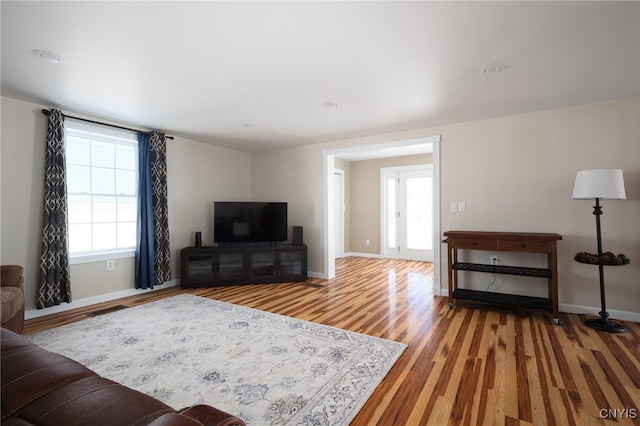 living room with baseboards and light wood-style floors