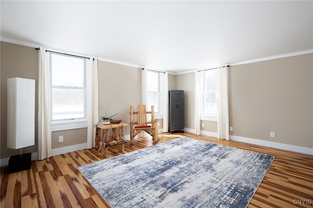 sitting room with plenty of natural light, light wood-type flooring, and baseboards