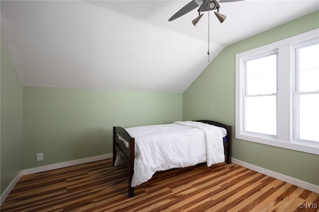 bedroom with vaulted ceiling, wood finished floors, a ceiling fan, and baseboards