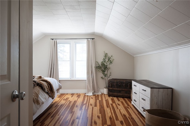 bonus room featuring baseboards, light wood-style floors, and vaulted ceiling