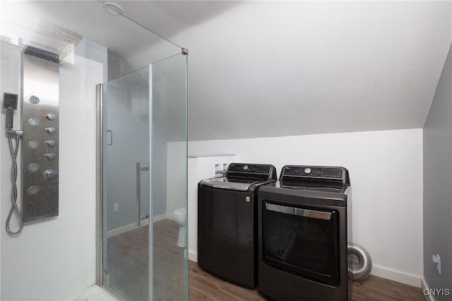 laundry room featuring washing machine and dryer, baseboards, and wood finished floors