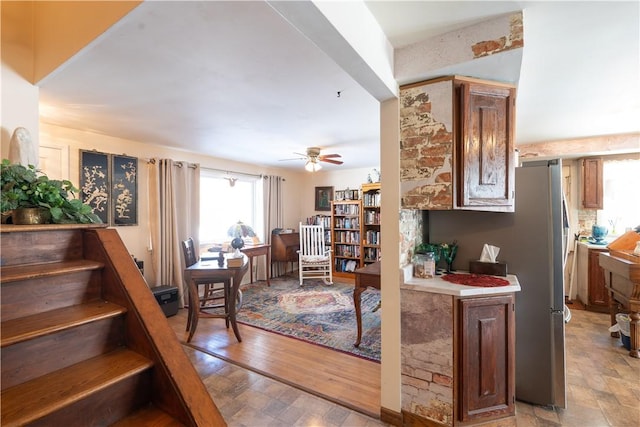 interior space with a ceiling fan and stone finish floor