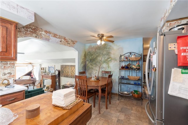 dining space with stone finish floor and ceiling fan