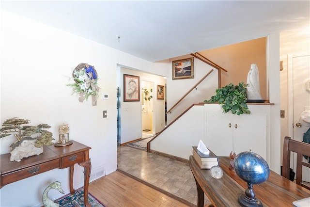 entryway featuring stairs, light wood-style flooring, visible vents, and baseboards