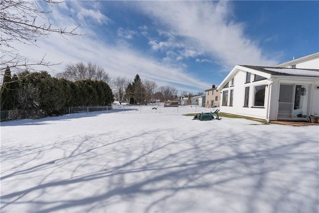 yard covered in snow featuring fence