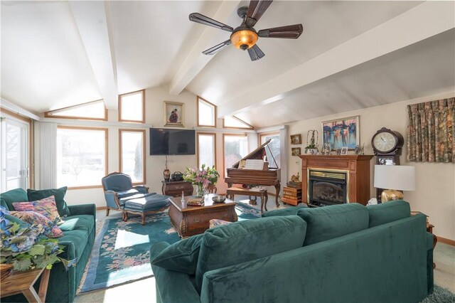 carpeted living area featuring baseboards, a glass covered fireplace, vaulted ceiling with beams, and ceiling fan