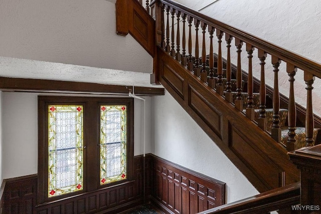 stairs featuring wainscoting