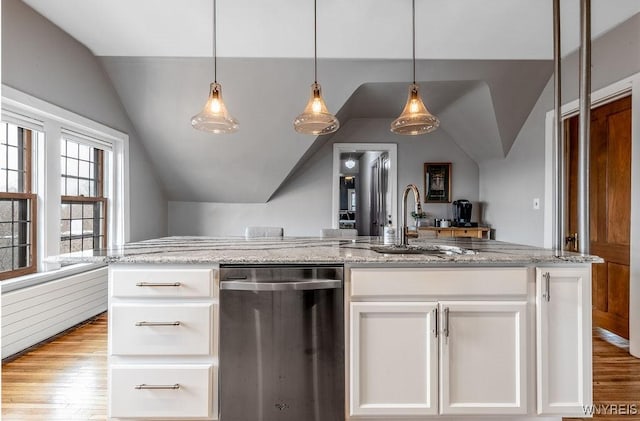 kitchen featuring wood finished floors, light stone countertops, a sink, vaulted ceiling, and white cabinetry