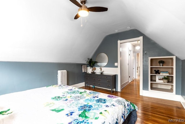 bedroom featuring radiator, ceiling fan, baseboards, lofted ceiling, and wood finished floors