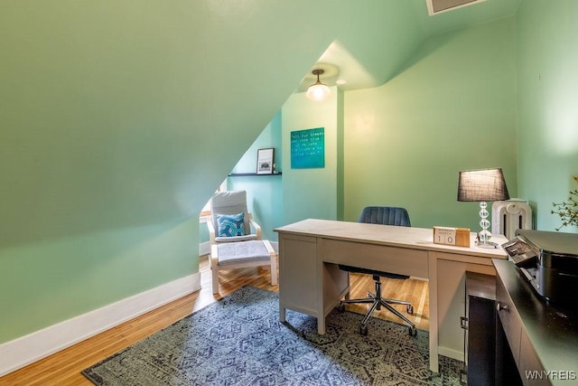 office space featuring baseboards, lofted ceiling, and wood finished floors