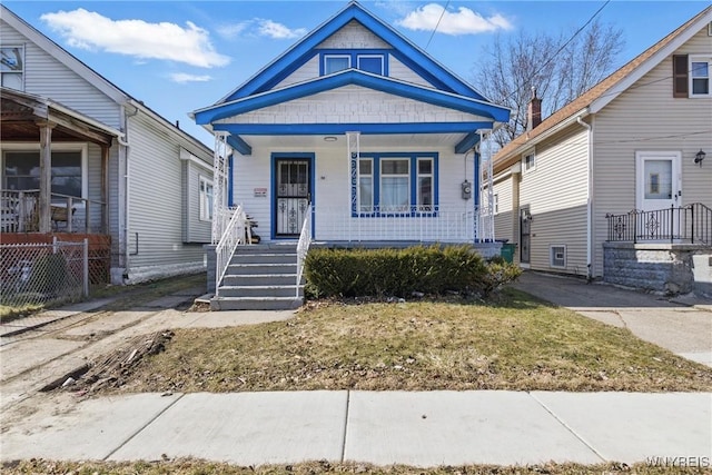 view of front of home with a porch and fence