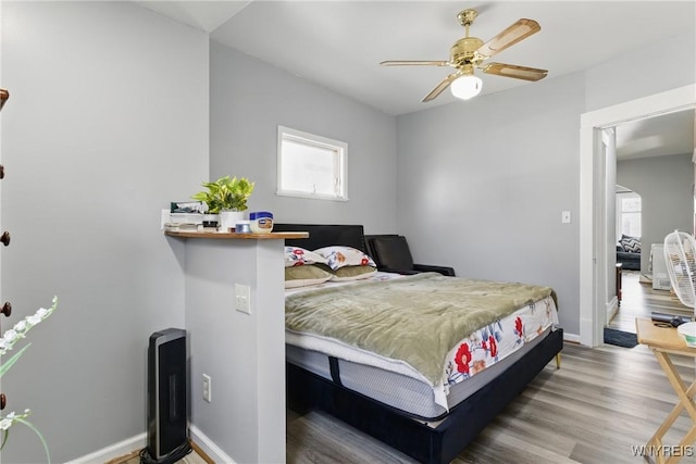 bedroom with baseboards and wood finished floors