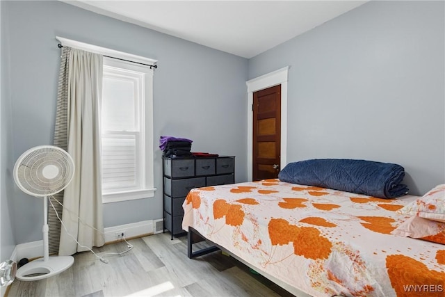 bedroom with baseboards and light wood finished floors