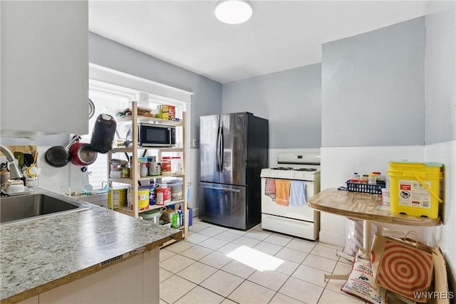 kitchen featuring a sink, appliances with stainless steel finishes, and light tile patterned floors