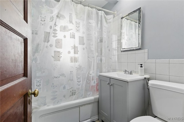 full bathroom featuring vanity, tile walls, toilet, and shower / bath combo