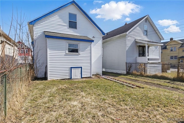 back of house featuring a lawn and fence