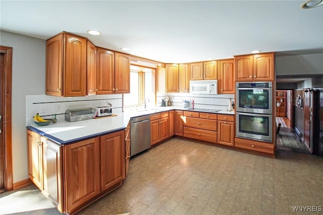 kitchen featuring backsplash, appliances with stainless steel finishes, light countertops, and brown cabinets