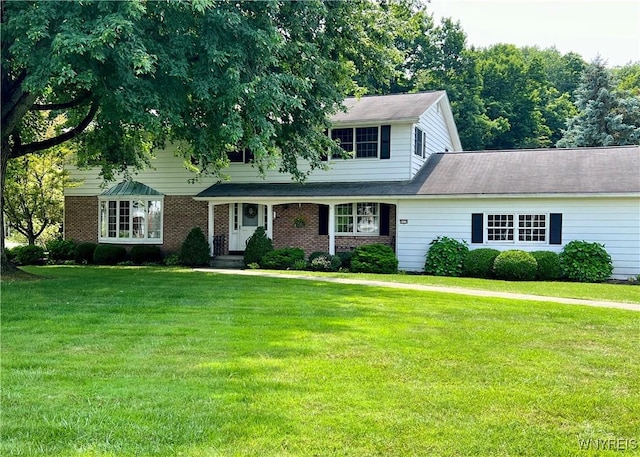 view of front facade with brick siding and a front yard