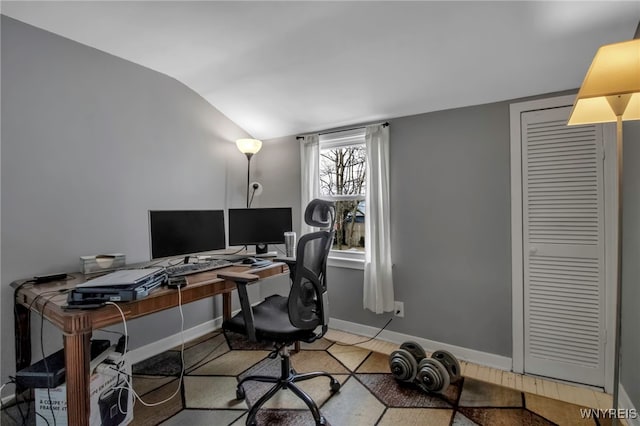 office space with lofted ceiling and baseboards