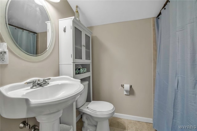 bathroom with baseboards, a sink, tile patterned flooring, curtained shower, and toilet