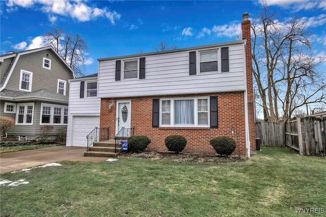 split level home featuring brick siding, fence, concrete driveway, a front yard, and a chimney