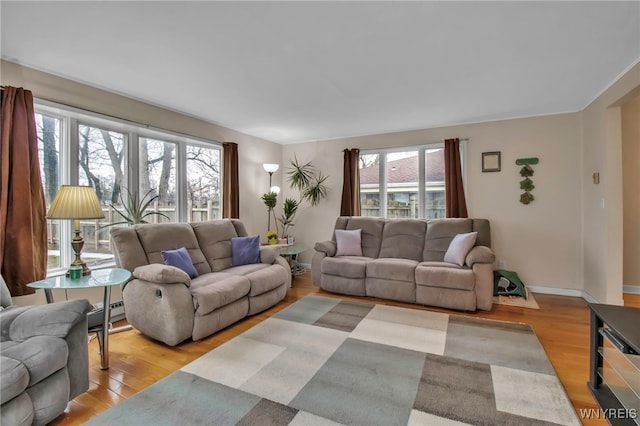 living room with a healthy amount of sunlight, light wood-type flooring, and baseboards