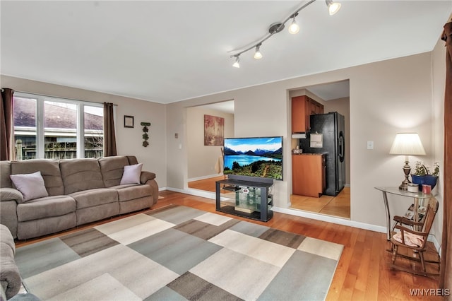 living area with light wood-type flooring and baseboards