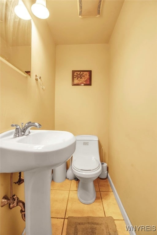 bathroom with tile patterned floors, toilet, and baseboards