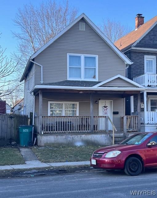 view of front of home with a porch and fence