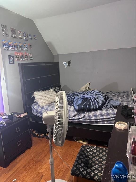 bedroom featuring lofted ceiling and wood finished floors