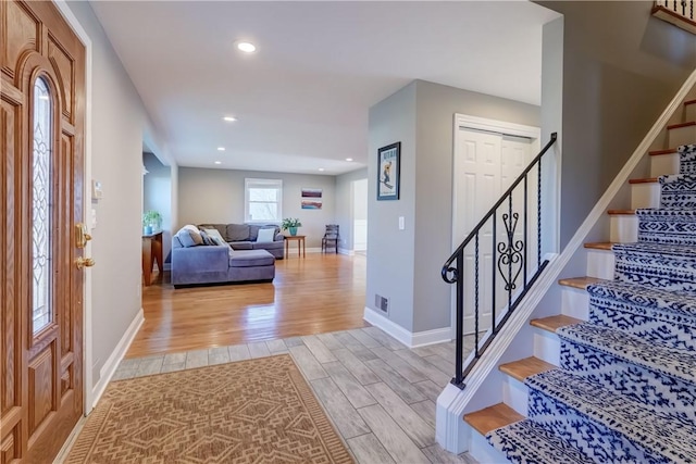 foyer entrance featuring stairway, visible vents, baseboards, recessed lighting, and light wood-type flooring