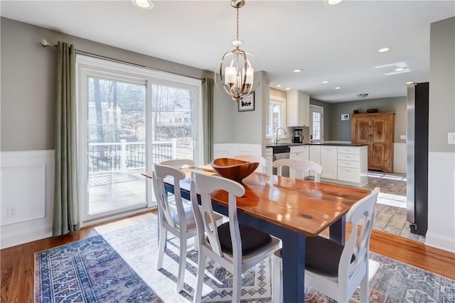 dining space with recessed lighting, light wood-style floors, and wainscoting