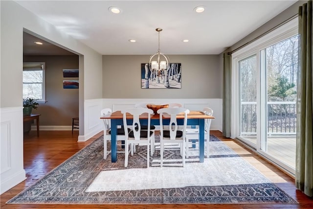 dining area featuring recessed lighting, an inviting chandelier, wood finished floors, and wainscoting