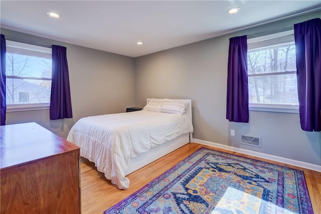 bedroom with recessed lighting, visible vents, baseboards, and wood finished floors