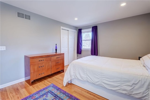 bedroom featuring baseboards, visible vents, light wood-style flooring, recessed lighting, and a closet