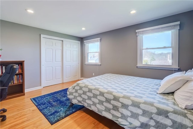 bedroom with recessed lighting, a closet, baseboards, and wood finished floors