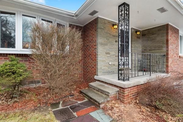 entrance to property featuring brick siding