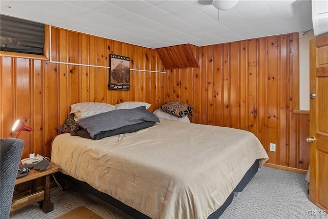 carpeted bedroom with wooden walls