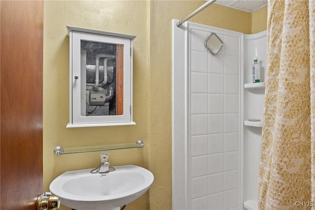 bathroom featuring a shower with shower curtain and a sink