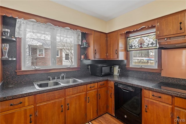 kitchen featuring black appliances, brown cabinetry, and a sink