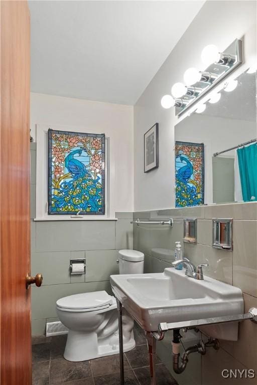 bathroom featuring visible vents, toilet, a shower with shower curtain, and a sink