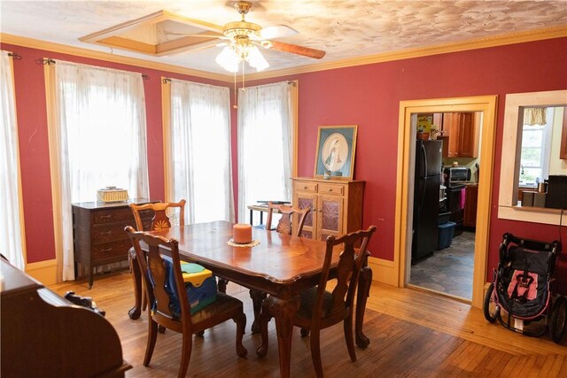 dining room featuring baseboards, a ceiling fan, light wood-style floors, and ornamental molding