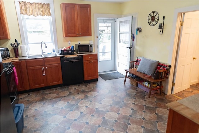 kitchen with a sink, stainless steel microwave, dishwasher, and light countertops
