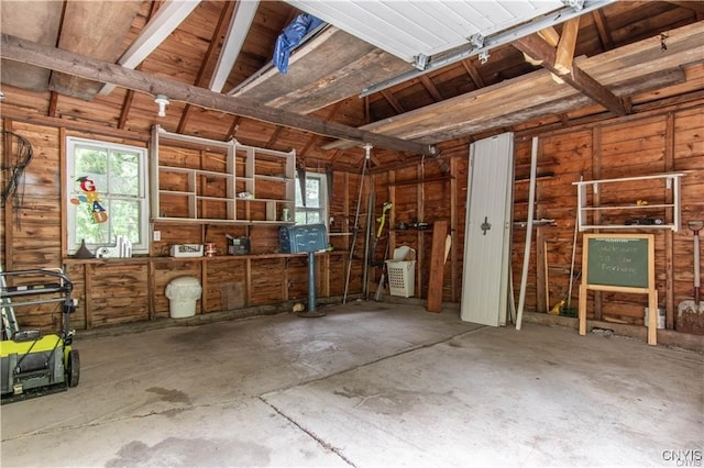 misc room featuring unfinished concrete floors and a garage