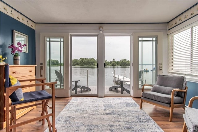 sunroom featuring a water view