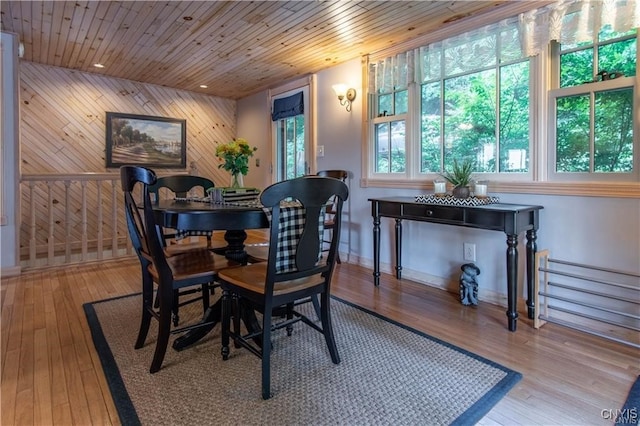 dining space featuring wooden walls, wooden ceiling, and hardwood / wood-style flooring