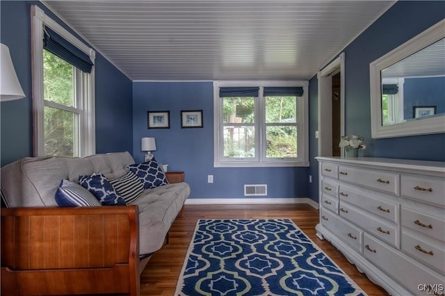 sitting room featuring visible vents, baseboards, and wood finished floors