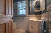 bathroom featuring tile walls and a sink