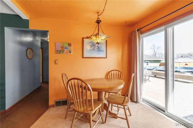 dining area with visible vents, light carpet, and baseboards