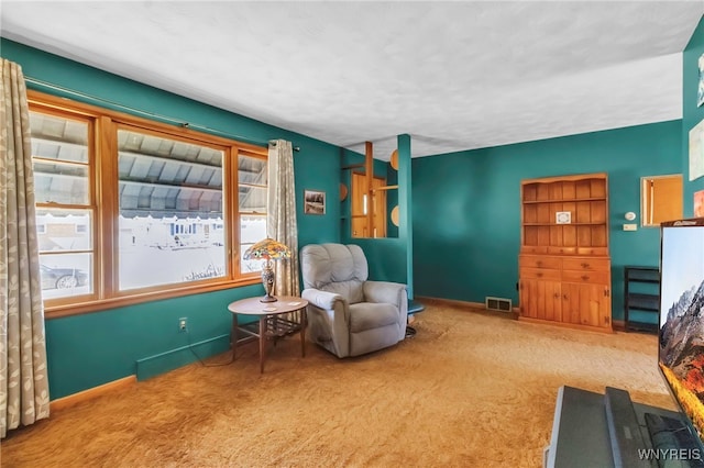 sitting room featuring visible vents, carpet flooring, and baseboards